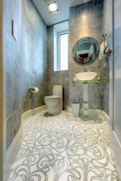 A bathroom with a toilet , sink and mirror.