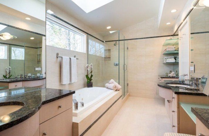 A bathroom with two sinks , a tub and a shower.