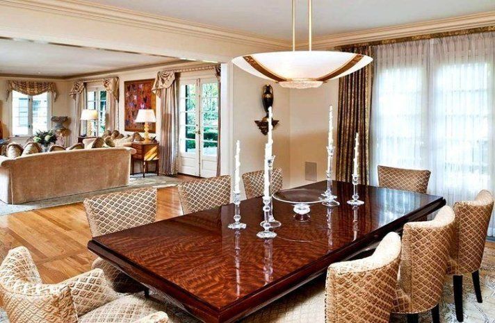 A dining room with a large wooden table and chairs