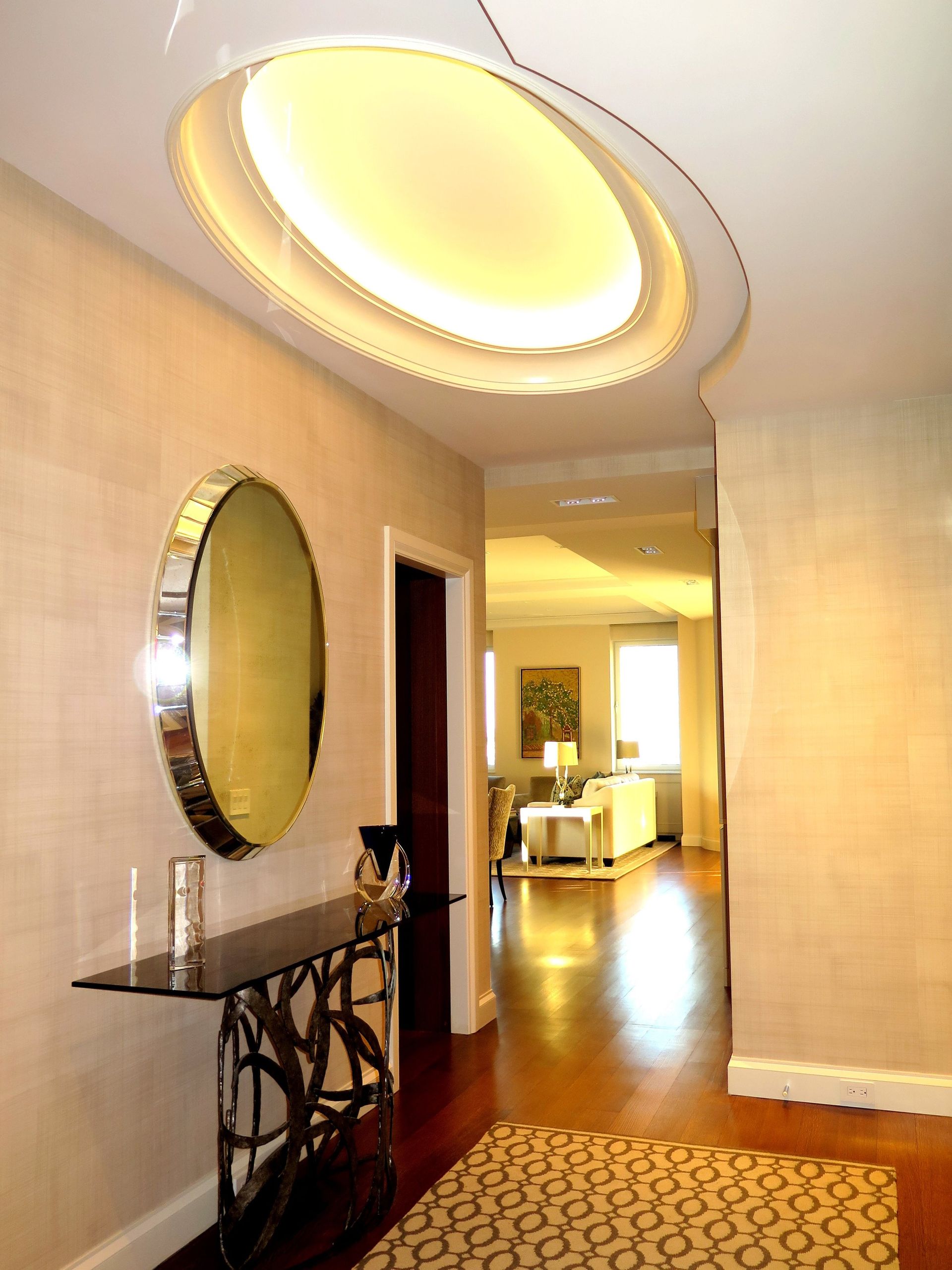 A hallway with a round mirror on the wall