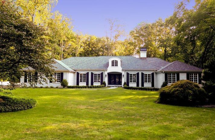 A large white house with a green roof and black shutters