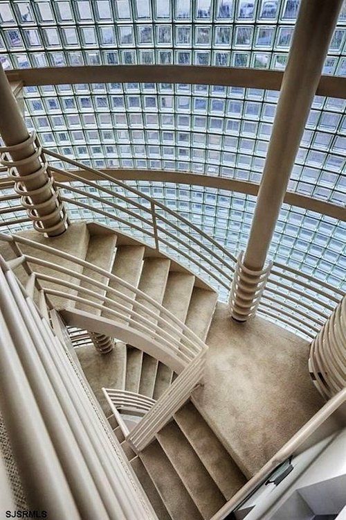 A spiral staircase in a building with a glass ceiling.
