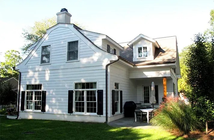 A white house with black shutters and a porch