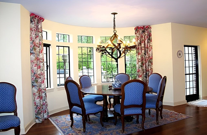 A dining room with a table and chairs and a chandelier