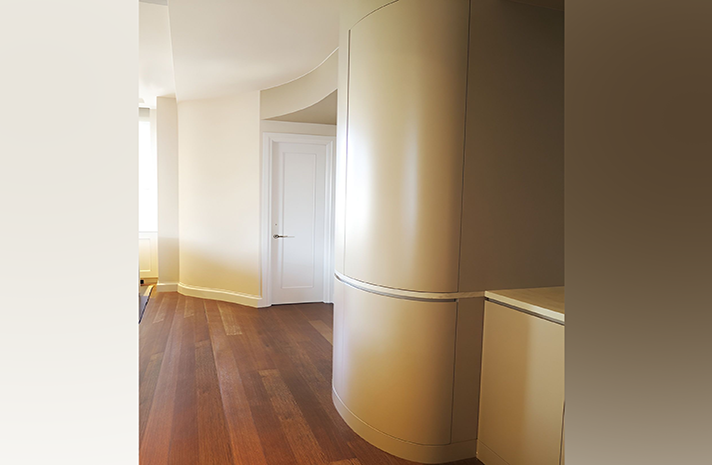 A hallway with a curved wall and a wooden floor