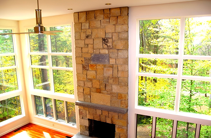 A living room with a fireplace and lots of windows