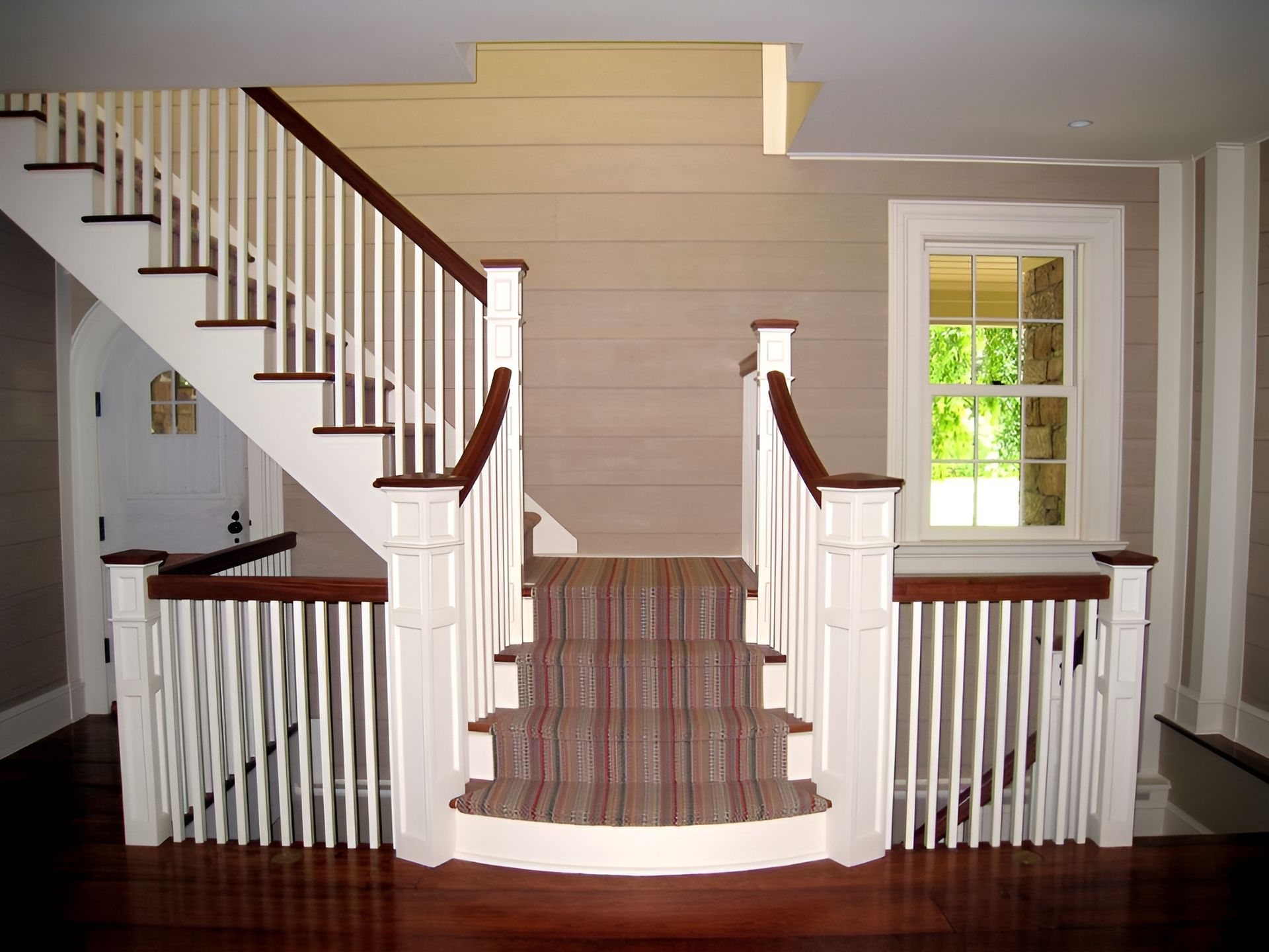 A staircase with white railings and a red carpet