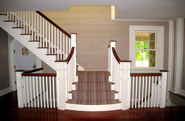 A staircase with a striped carpet on the steps