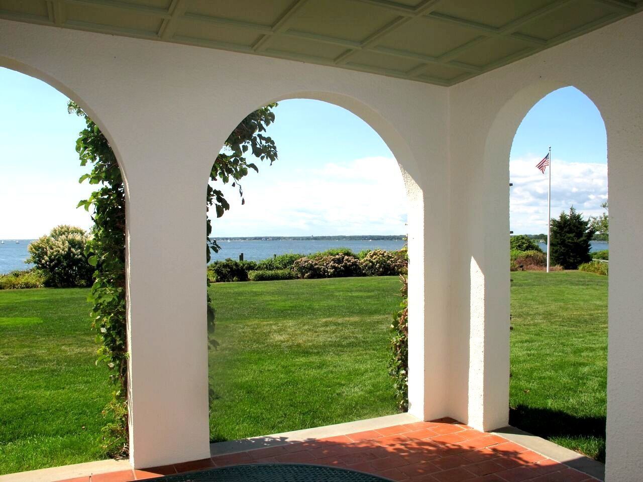 A view of a lake through arches on a porch