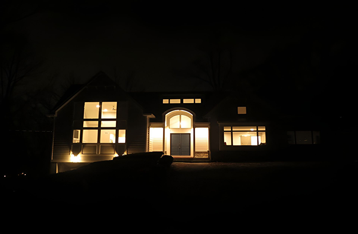 The front of a house is lit up at night