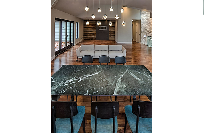 A living room with a marble table and chairs and a couch.