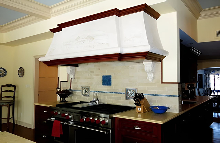 A kitchen with a stove top oven and a hood above it