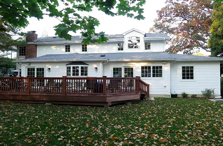 A large white house with a large deck in front of it