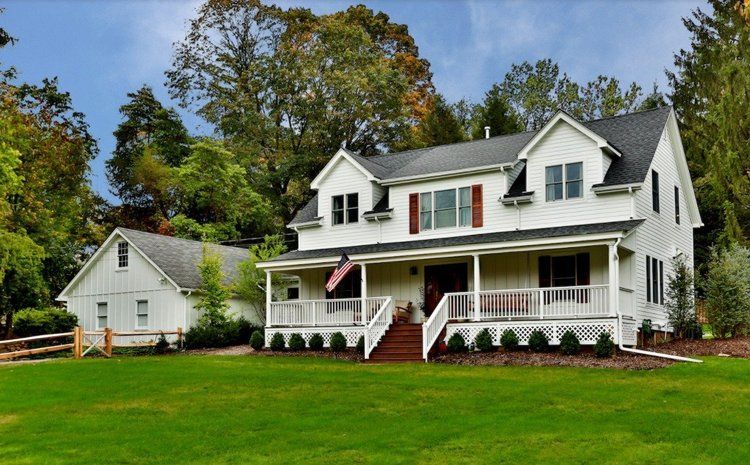 A large white house with a large porch and stairs