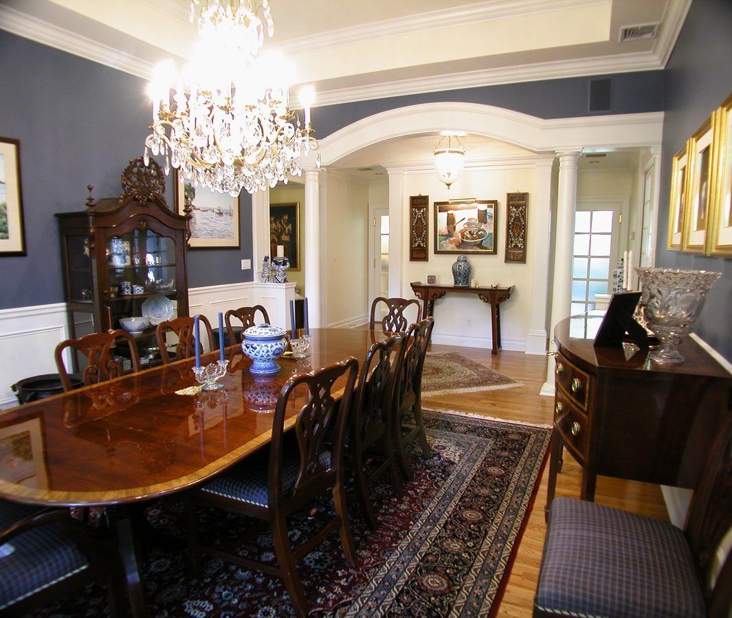 A dining room with a table and chairs and a chandelier