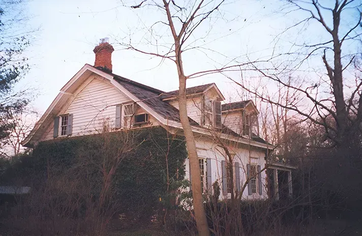 An old white house with a chimney on the roof