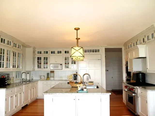 A kitchen with white cabinets and a large island