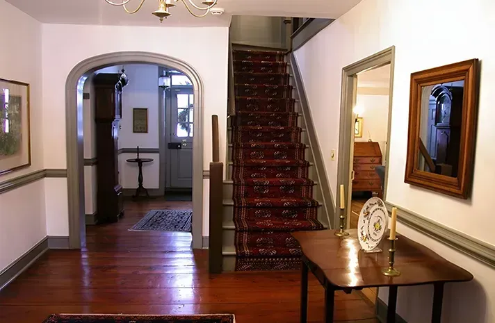 A hallway with stairs leading up to the second floor of a house.