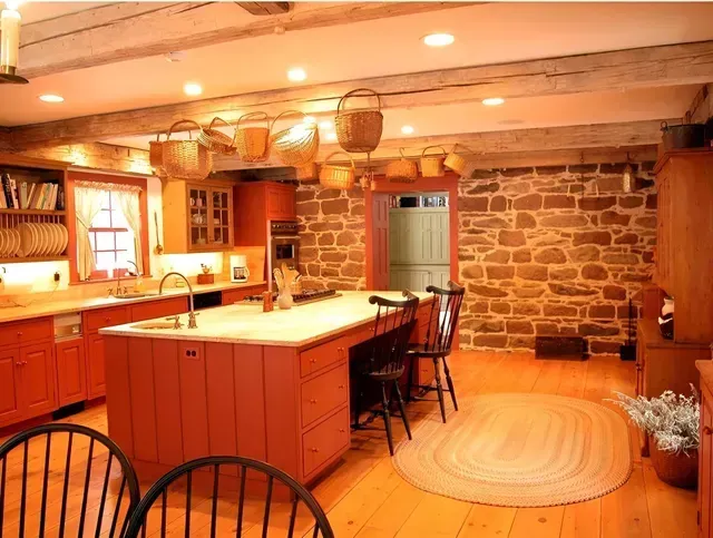A kitchen with a large island and a stone wall