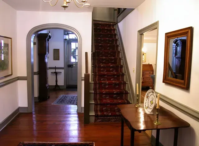 A hallway with stairs leading up to the second floor of a house.