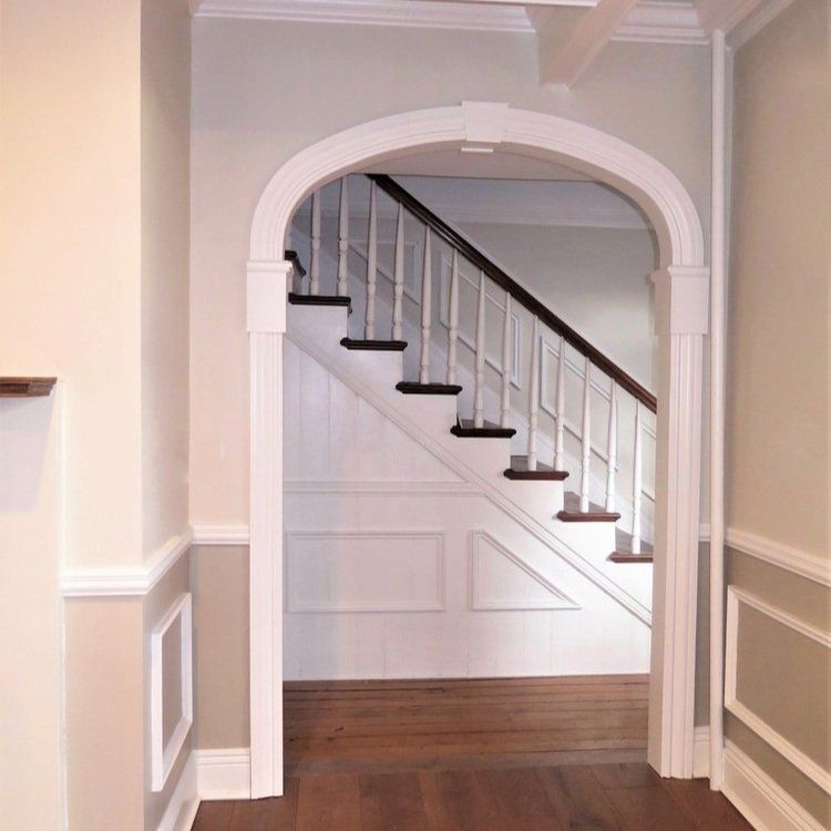 A hallway with a staircase leading up to it
