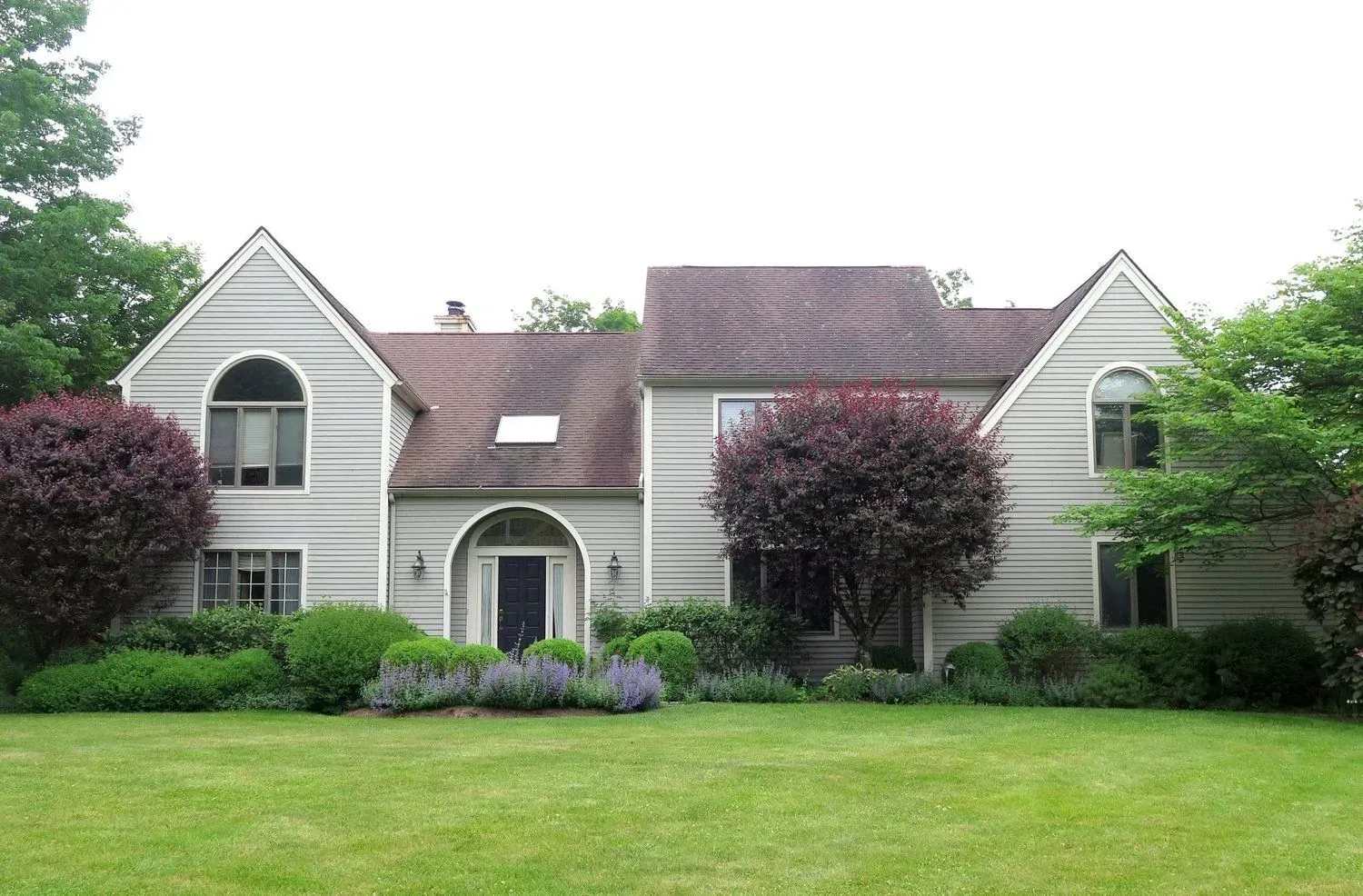 A large house with a lush green lawn in front of it