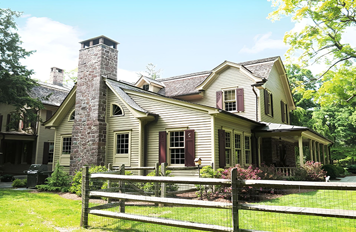 A large house with a wooden fence in front of it.