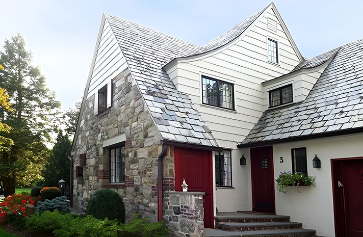 A large white house with a stone facade and a red door