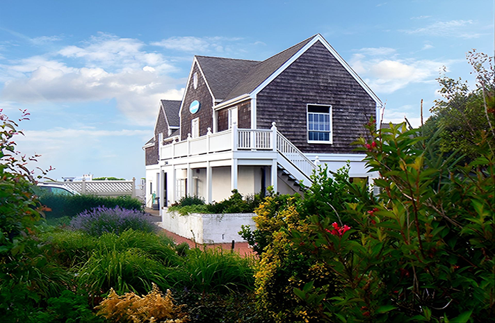 A large house is surrounded by trees and bushes