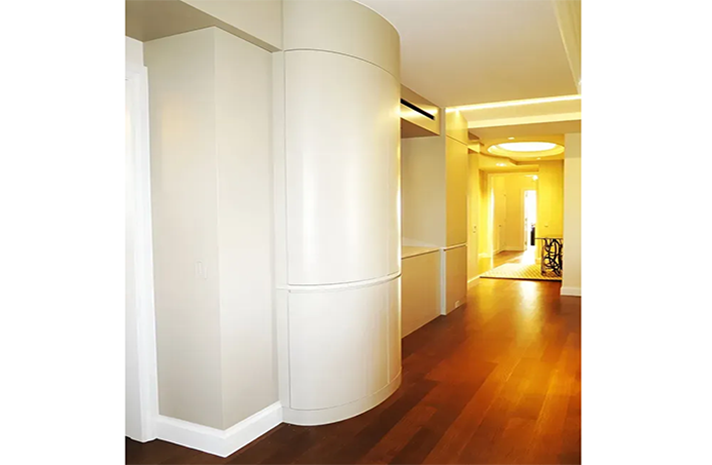 A hallway with a curved wall and a wooden floor.