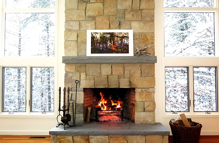 A fireplace with a picture hanging above it