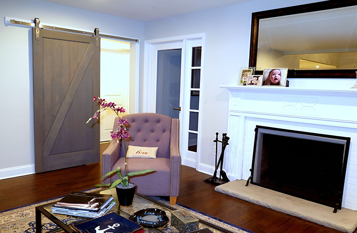 A living room with a fireplace and a sliding barn door
