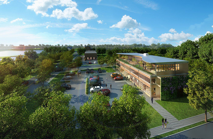 An aerial view of a large building surrounded by trees and a lake.