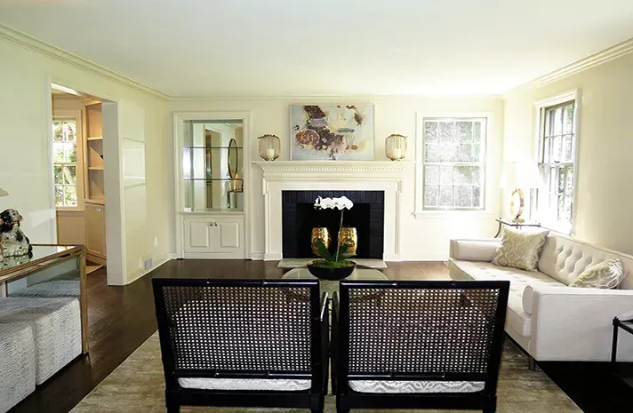 A living room with a couch , chairs and a fireplace.