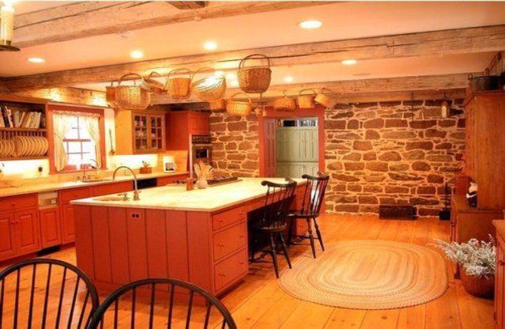 A kitchen with a large island and a stone wall