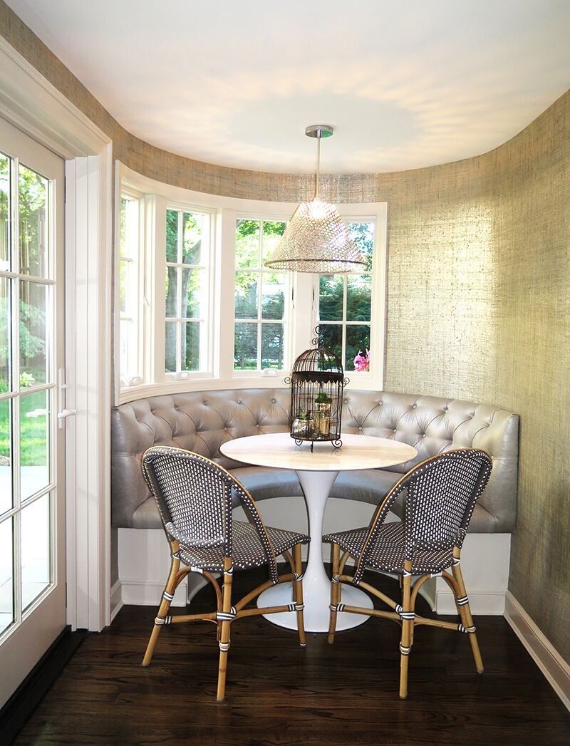 A dining room with a table and chairs in front of a window