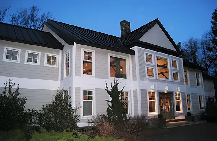 A large house with a black roof and lots of windows