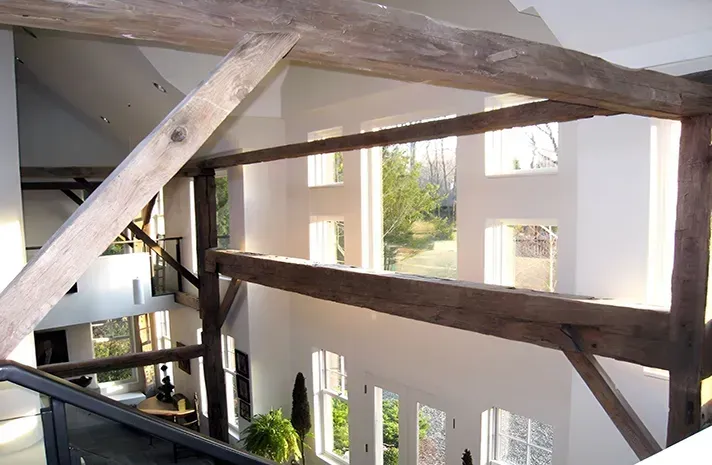 A room with a lot of windows and wooden beams