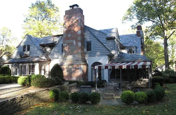 A large house with a red and white awning in front of it