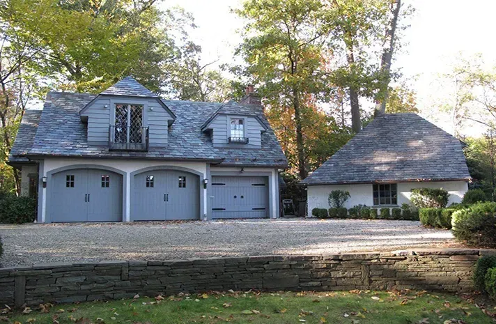 A house with three garage doors and a stone wall