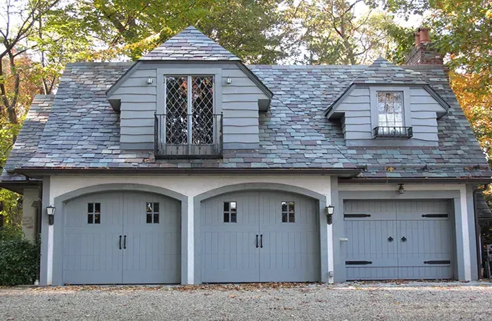 A house with three garage doors and a slate roof