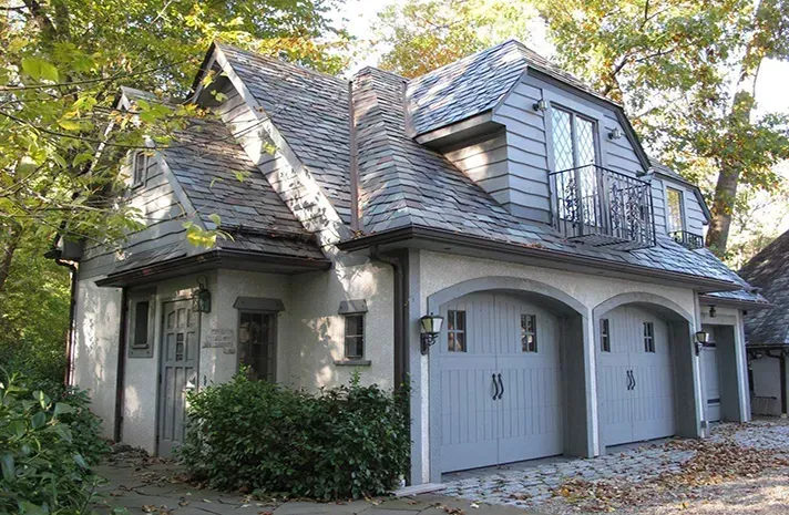 A large house with two garage doors and a balcony.