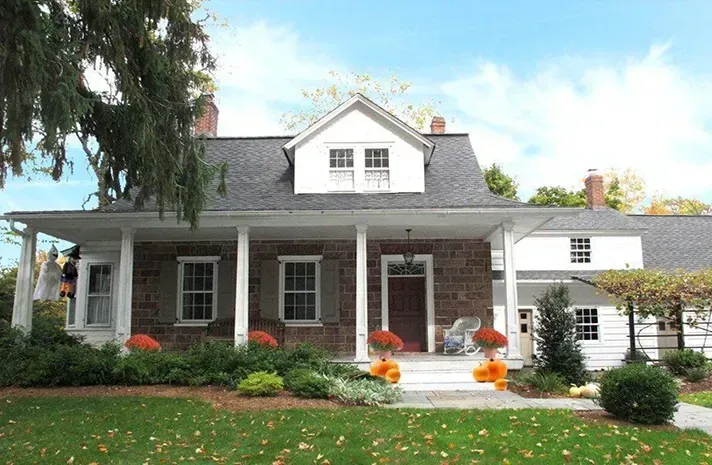A large brick house with a white trim and a porch