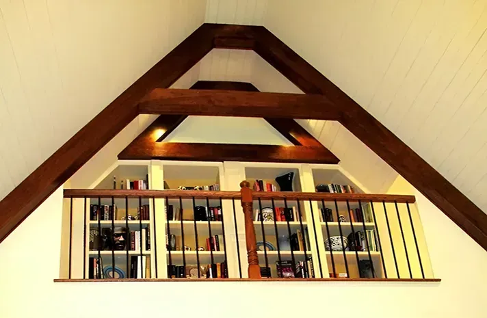 A room with a balcony and shelves filled with books.