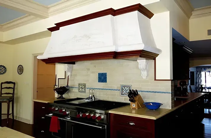 A kitchen with a stove top oven and a hood above it