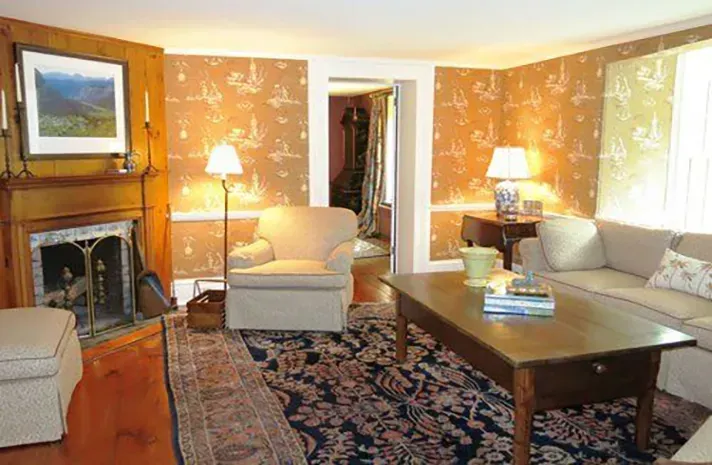 A living room with a couch , chair , coffee table and fireplace.