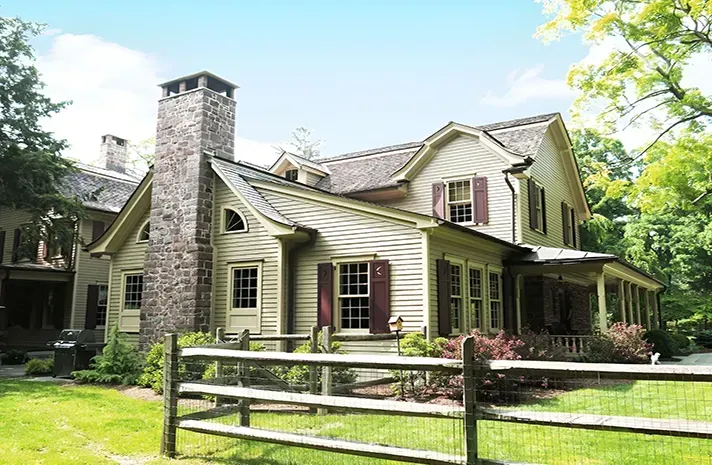 A large house with a wooden fence in front of it.
