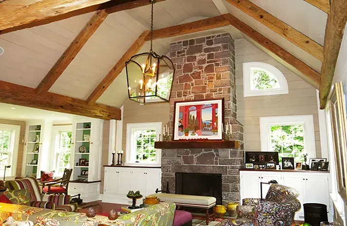 A living room with a stone fireplace and a vaulted ceiling