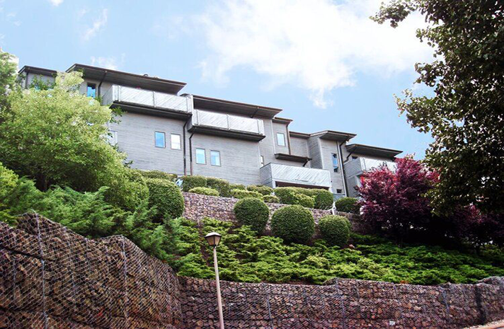 A large building sitting on top of a hill surrounded by trees and bushes
