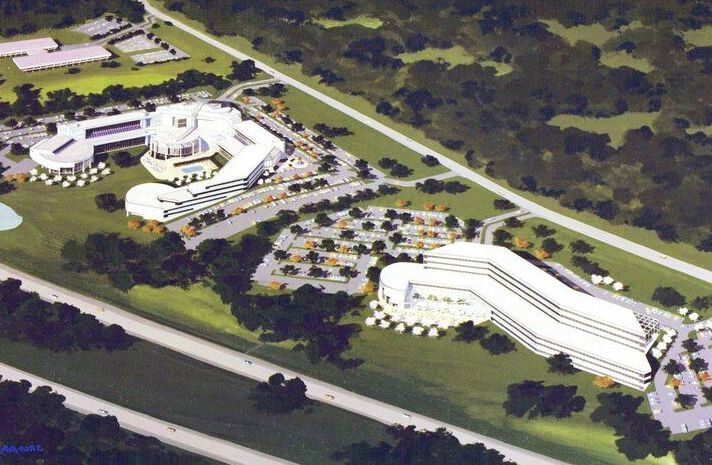 An aerial view of a large white building surrounded by trees